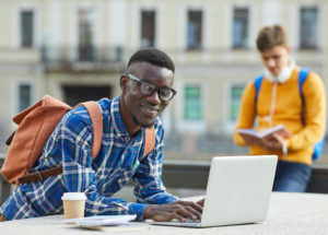 Portrait,Of,Contemporary,African,Student,Using,Laptop,Outdoors,In,College