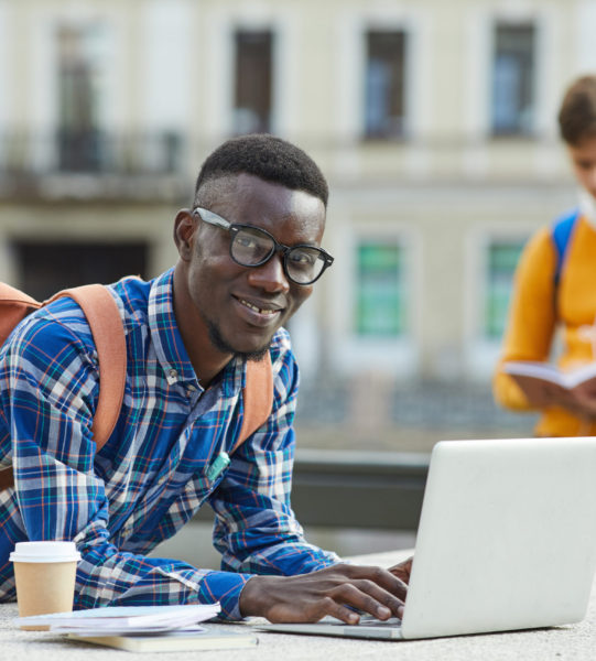 Portrait,Of,Contemporary,African,Student,Using,Laptop,Outdoors,In,College Portrait,Of,Contemporary,African,Student,Using,Laptop,Outdoors,In,College